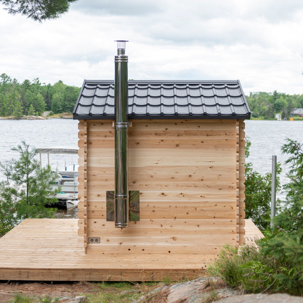 LeisureCraft CT Cabin Sauna with wood-burning chimney by the water